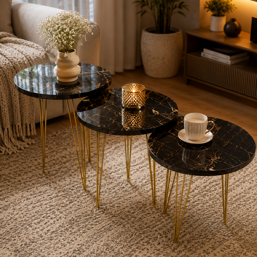 Set of three black marble tables with gold legs in a living room setting.