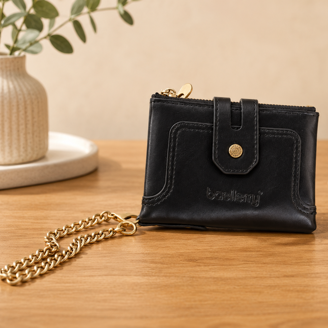 Black leather wallet closed with snap button strap and gold zipper