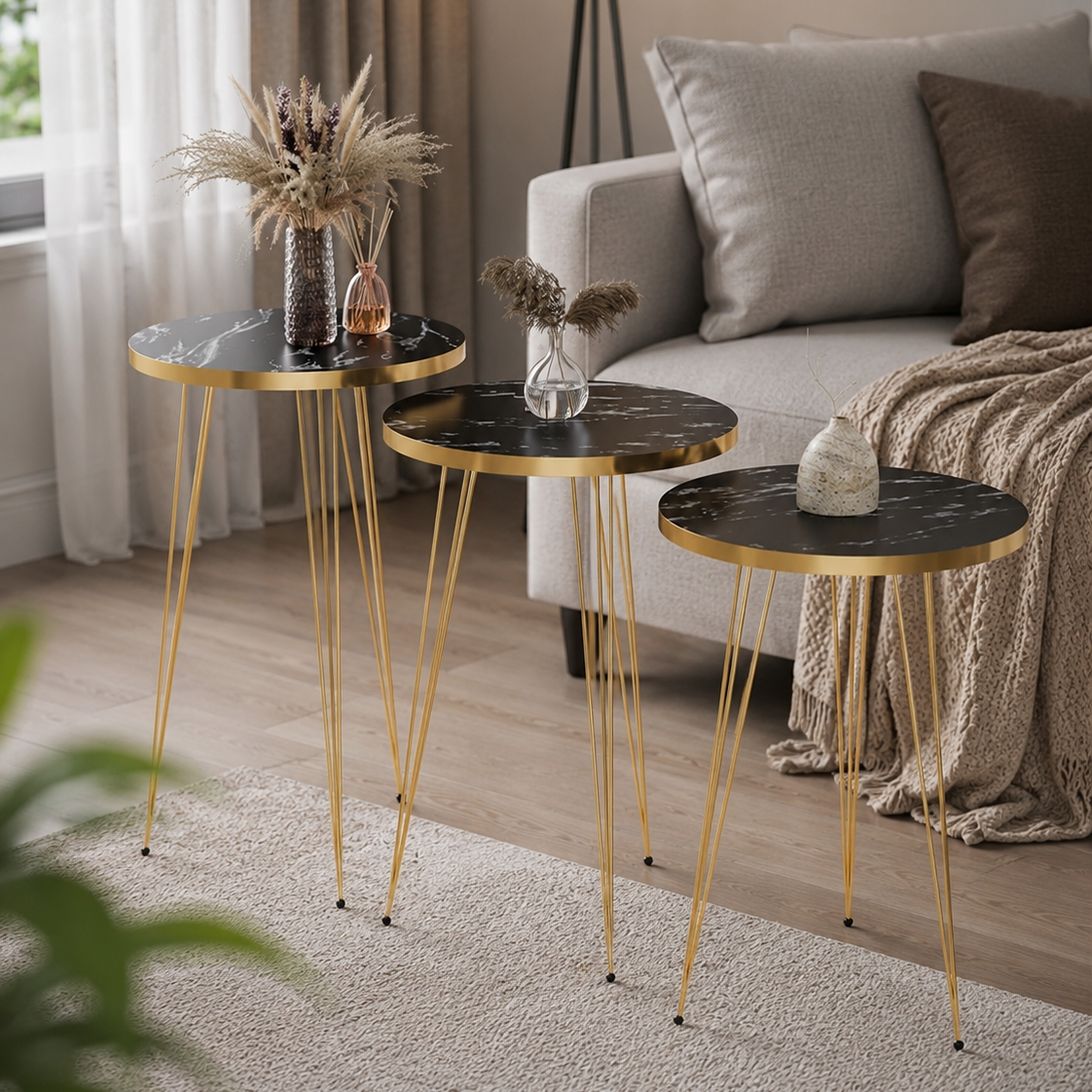 Set of three round side tables with gold legs in a living room setting.