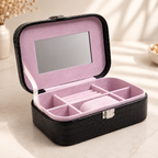 Open black jewelry box with mirror, ring rolls, and lilac velvet interior