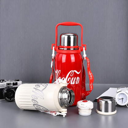 Red Coca-Cola thermos with white lid on a gray surface with a striped background
