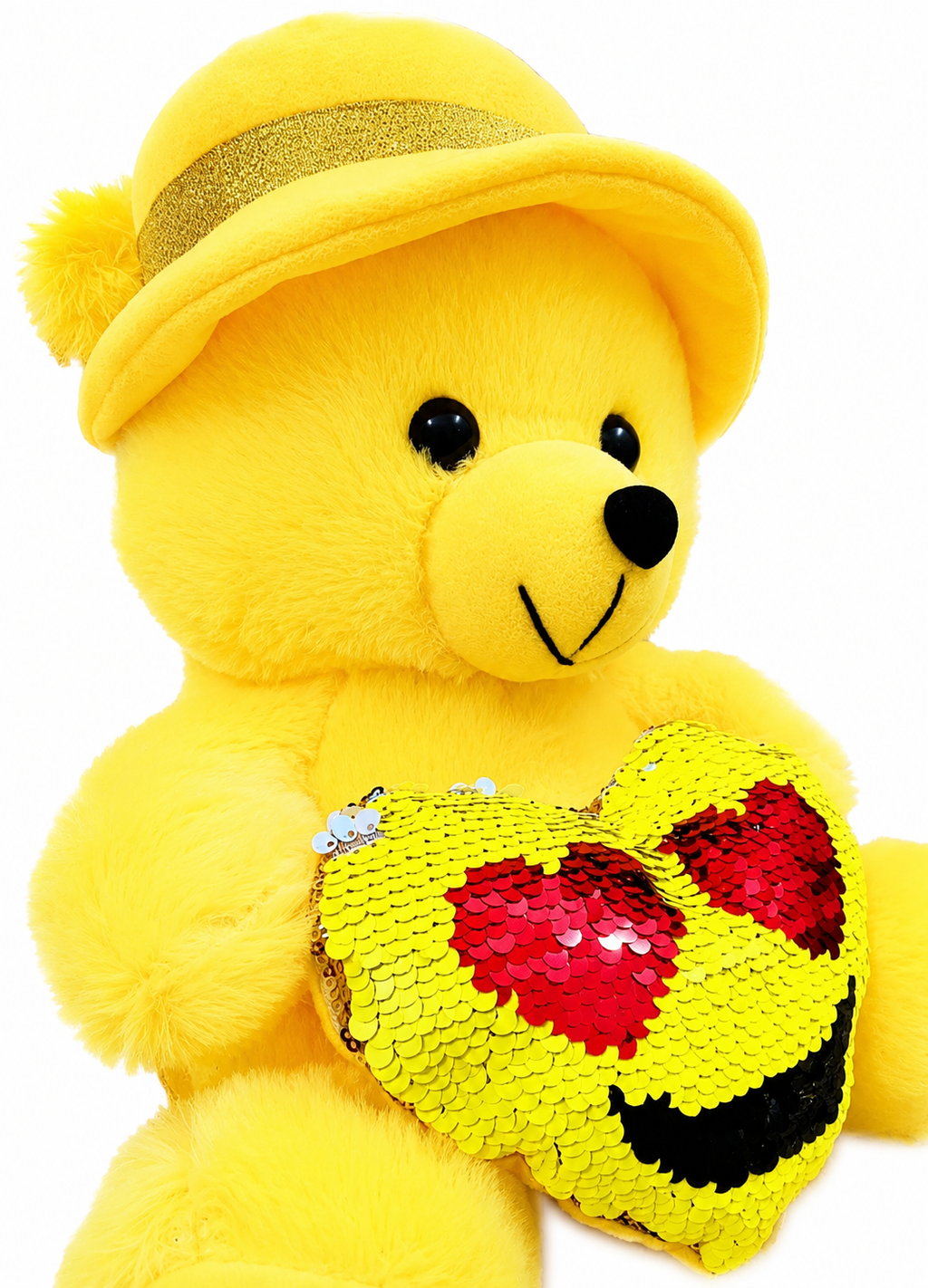 Yellow teddy bear with a sequined heart and yellow hat on a white background