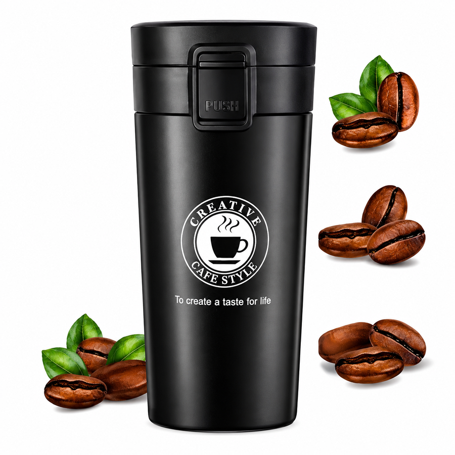 Matte black stainless steel travel coffee mug surrounded by fresh coffee beans and leaves
