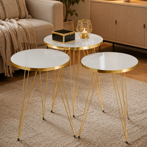 Set of three round side tables with gold metal legs in a living room with candle stand 
setting.